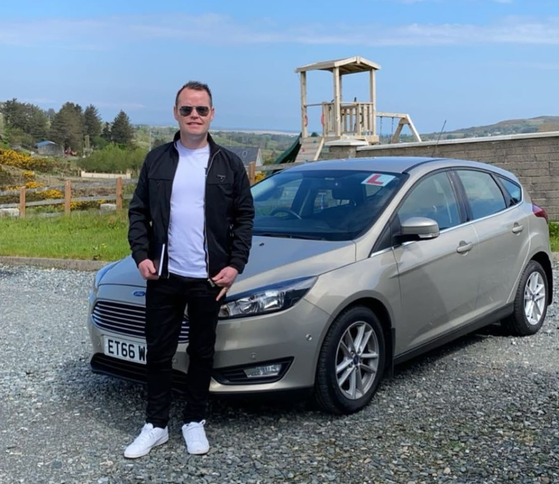 Cornelius Gallagher standing beside the Errigal School of Motoring tuition car in Donegal